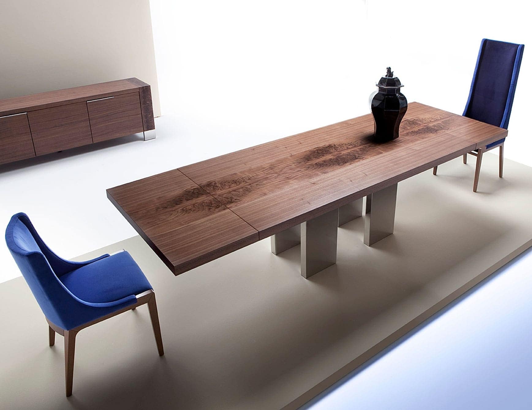 Rectangular wooden dining table with metal legs and two blue chairs